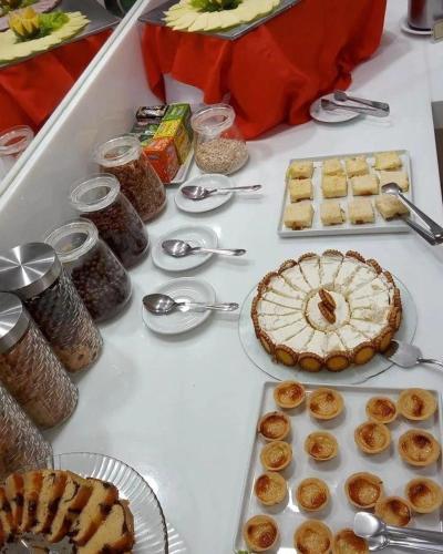een tafel met taarten en andere etenswaren erop bij Alimar Hotel in Natal