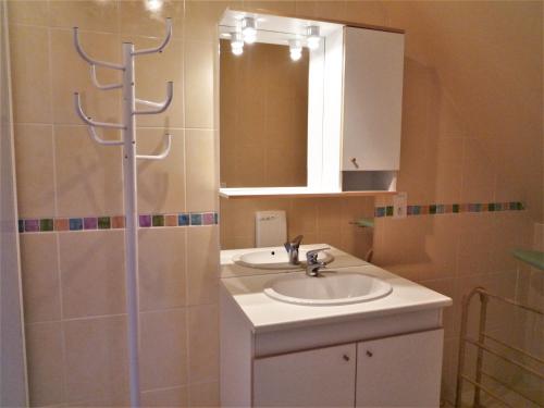 La salle de bains est pourvue d'un lavabo, d'un miroir et d'une douche. dans l'établissement LE BUIS, à Scrignac