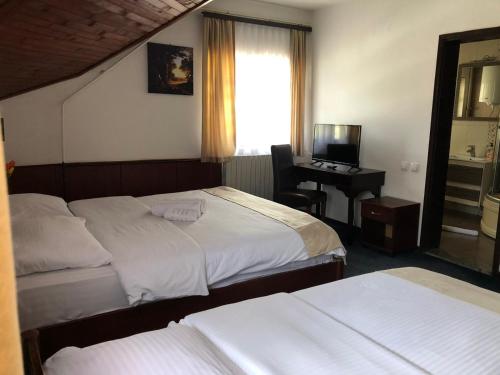 a hotel room with two beds and a desk at Sobe na Jošanici in Jošanička Banja