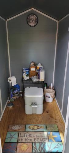a small bathroom with a toilet and a rug at Sleep Birds glamping trailer 5min to the beach in Nokomis