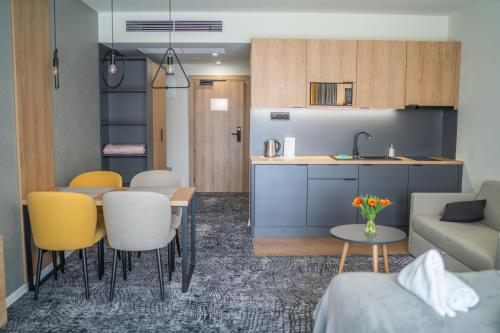 a kitchen and living room with a couch and a table at Lux apartmán v hoteli Akvamarín Bešenová in Bešeňová