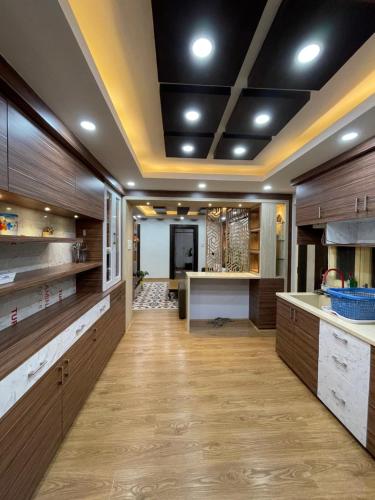 uma grande cozinha com armários de madeira e uma ilha de cozinha em Welcome Home Bhaisepati em Patan