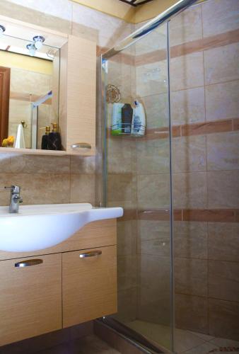a bathroom with a sink and a glass shower at Vasiliki's Residence Amazing View in Kissamos