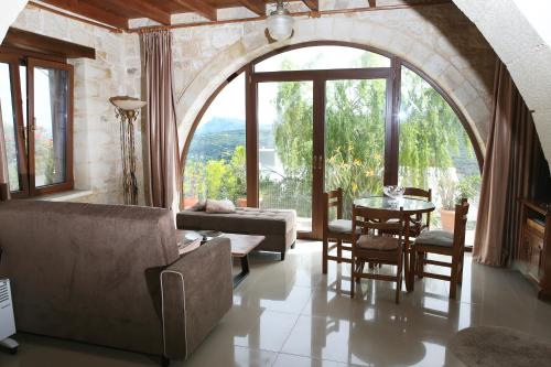a living room with an archway and a table and chairs at Vasiliki's Residence Amazing View in Kissamos