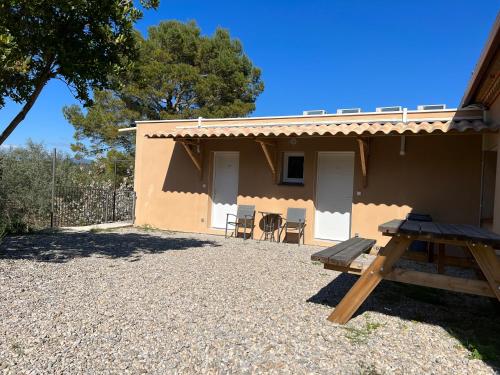 a house with a picnic table in front of it at DOMAINE MAXXIM in Clermont-lʼHérault