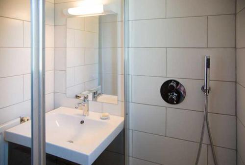 une salle de bain blanche avec un lavabo et une douche dans l'établissement Gîte du Loiret, à Saint-Hilaire-Saint-Mesmin