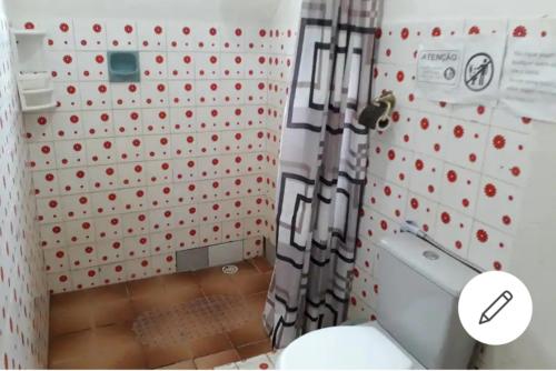 a bathroom with a toilet and a wall with red dots at Casa amora olinda in Olinda
