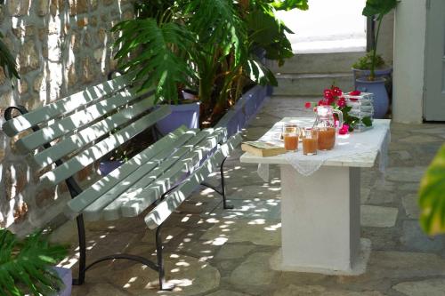 a bench with a table with drinks on it at Pension Erofili in Hydra