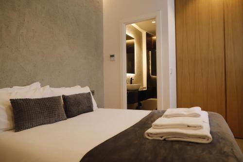 Un dormitorio con una cama con una toalla. en MEDINA HOMES PUENTE ROMANO, en Córdoba