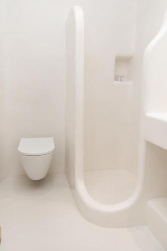 a white bathroom with a toilet and a shower at Krina Mare Boutique Hotel in Naxos Chora