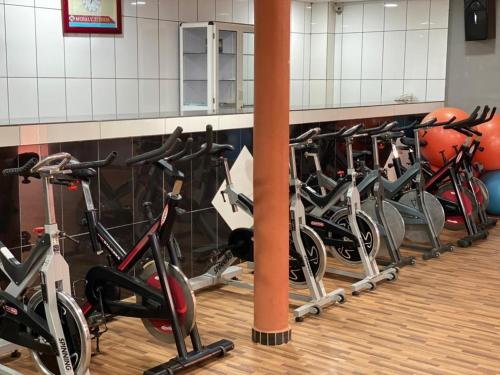 una fila de bicicletas alineadas en un gimnasio en Mosaly Hotel PK10, en Porto Novo