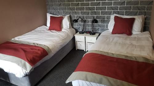 two beds sitting next to each other in a room at Forresters Bar & French Restaurant with Rooms in Middleton in Teesdale