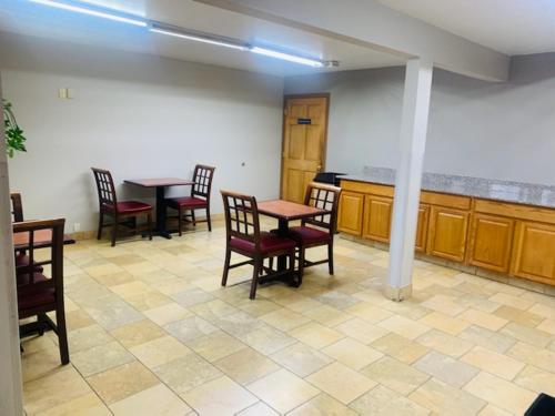 a dining room with tables and chairs in a room at Rodeway Inn Columbus West in Columbus
