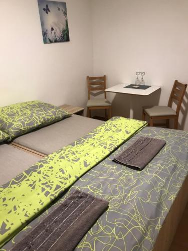 2 camas en una habitación con sillas y mesa en Ubytování ANEŽKA, en Lednice