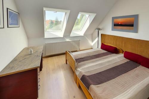 two beds in a small room with two windows at Highway House in Kecskemét