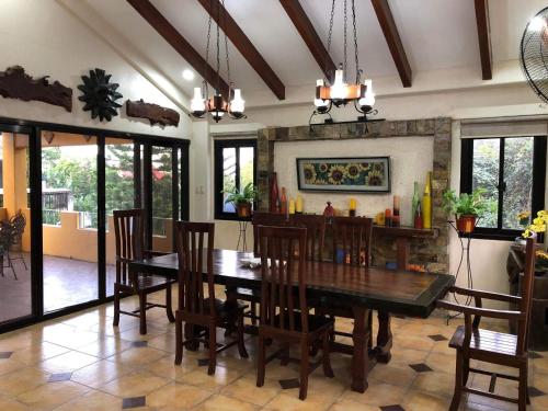 a dining room with a wooden table and chairs at Tagaytay BNR Guesthouse 4BR With Balcony 12-14 Guest in Tagaytay