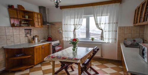 a kitchen with a table with a vase of flowers on it at Pensiunea Poienita Ursului in Fundata
