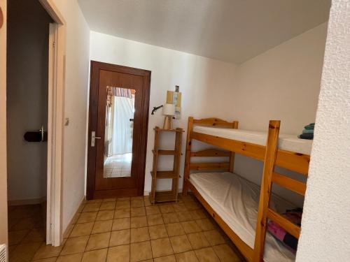 Cette chambre comprend 2 lits superposés et une porte. dans l'établissement L'Horizon, à Mimizan