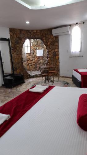a large bed in a room with a stone wall at Eco-Hotel Villa Elina in Ríohacha