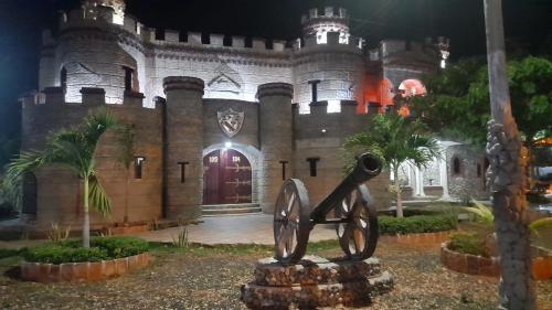 una estatua delante de un castillo por la noche en Eco-Hotel Villa Elina, en Ríohacha