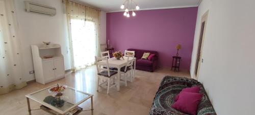 ein Wohnzimmer mit lila Wänden, einem Sofa und einem Tisch in der Unterkunft Il gabbiano al Capo in Palermo