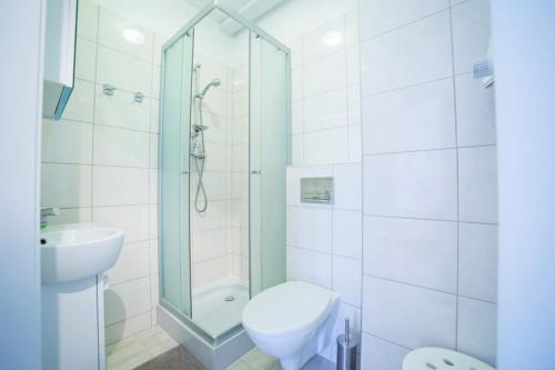a bathroom with a shower and a toilet and a sink at Apartament Paryski in Karpacz