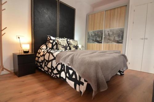 1 dormitorio con 1 cama con manta blanca y negra en Luna´s home. Precioso loft en Bollullos par del Condado, en Bollullos Par del Condado