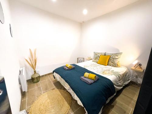 een slaapkamer met een bed met een blauwe deken en gele kussens bij Le numéro 12 Netflix Wifi in Cherbourg en Cotentin
