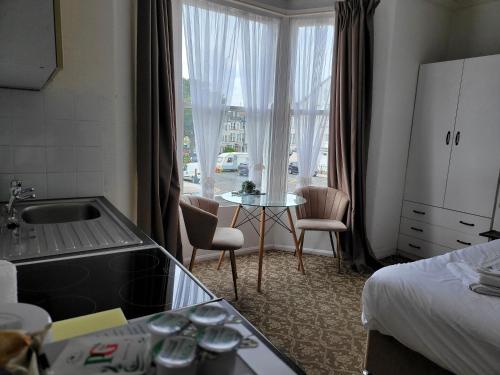 Seaside ground floor flat WIFI & FREE parking في سكرابورو: غرفه فندقيه مع مطبخ وسرير وطاوله