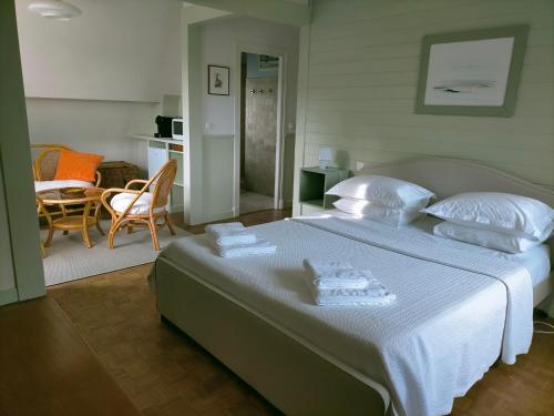 ein Schlafzimmer mit einem großen Bett mit weißer Bettwäsche und Kissen in der Unterkunft BnB La Néo Bretonne in Minihy-Tréguier