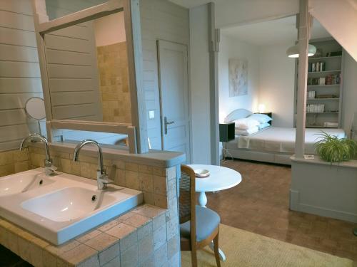une salle de bain avec un lavabo et une chambre avec un lit dans l'établissement BnB La Néo Bretonne, à Minihy-Tréguier