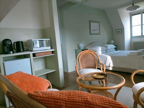 une chambre avec un lit, une table et des chaises dans l'établissement BnB La Néo Bretonne, à Minihy-Tréguier