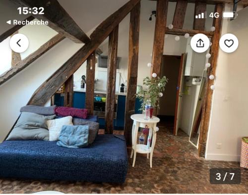 un salon avec un canapé bleu et une table dans l'établissement Cosy appartement quartier Latin Rue Mouffetard, à Paris