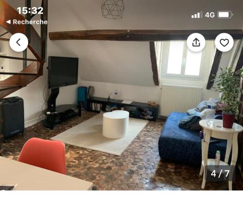 a living room with a blue couch and a table at Cosy appartement quartier Latin Rue Mouffetard in Paris