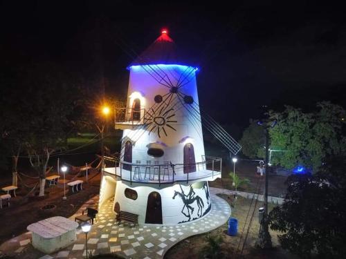 una casa luminosa con un reloj en ella por la noche en Eco-Hotel Villa Elina, en Ríohacha