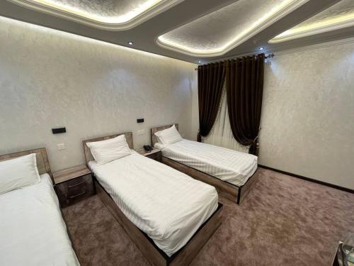 um pequeno quarto com 2 camas e uma janela em RAMZIYA NUR Guest house em Samarkand