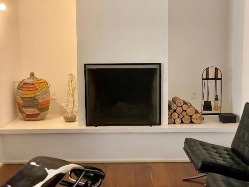 Tv LED en un estante de la sala de estar en Linda cobertura duplex no coração de Sao Paulo, en São Paulo