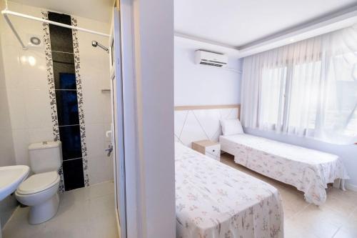 a bathroom with two beds and a toilet at Çeşme Flowers Hotel in Ildır