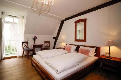 Schlafzimmer mit einem Bett und einem Wandspiegel in der Unterkunft Hotel Klostermühle Siebenborn in Maring-Noviand