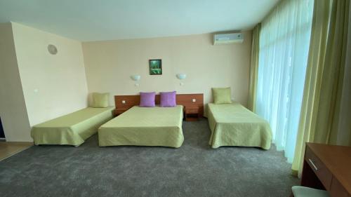 a hotel room with two beds and purple pillows at Hotel L&B- Free parking in Sunny Beach