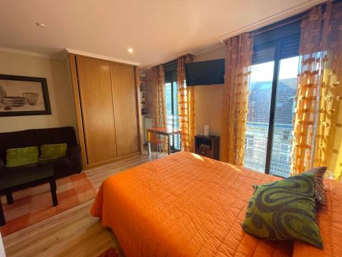 a bedroom with an orange bed and a large window at Ronda De Don Bosco52 By Vigovacaciones in Vigo