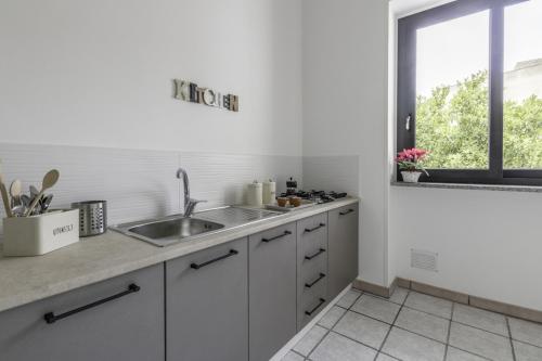 a white kitchen with a sink and a window at La Gemma del Salento Rooms&Apartments in Racale