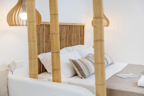 a bedroom with a white bed with a wooden headboard at Krina Mare Boutique Hotel in Naxos Chora