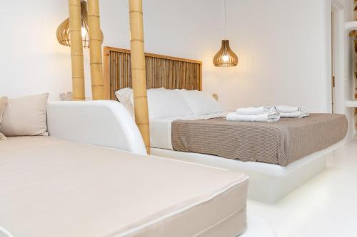 a bedroom with two beds and a couch at Krina Mare Boutique Hotel in Naxos Chora