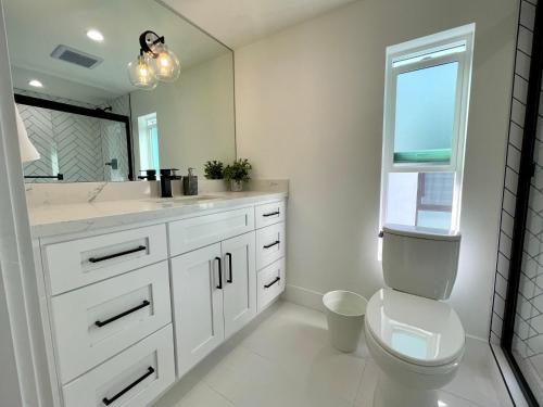 a bathroom with a toilet and a sink and a mirror at Exclusive Artist Gallery Home - Central LA Location in Los Angeles