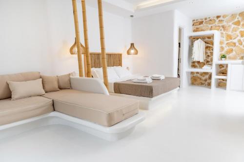 a white living room with a couch and a bed at Krina Mare Boutique Hotel in Naxos Chora