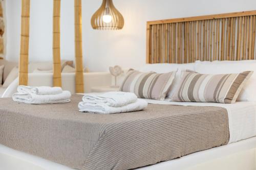 a bedroom with two beds with towels on a table at Krina Mare Boutique Hotel in Naxos Chora
