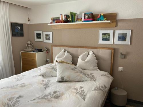 um quarto com uma cama com almofadas em Haus VALLESIA em Saas-Fee