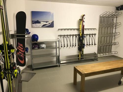 um quarto com esquis e snowboards numa parede em Haus VALLESIA em Saas-Fee