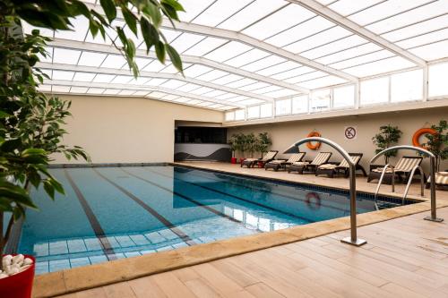 une grande piscine avec un plafond en verre dans l'établissement Idou Anfa Hôtel & Spa, à Casablanca